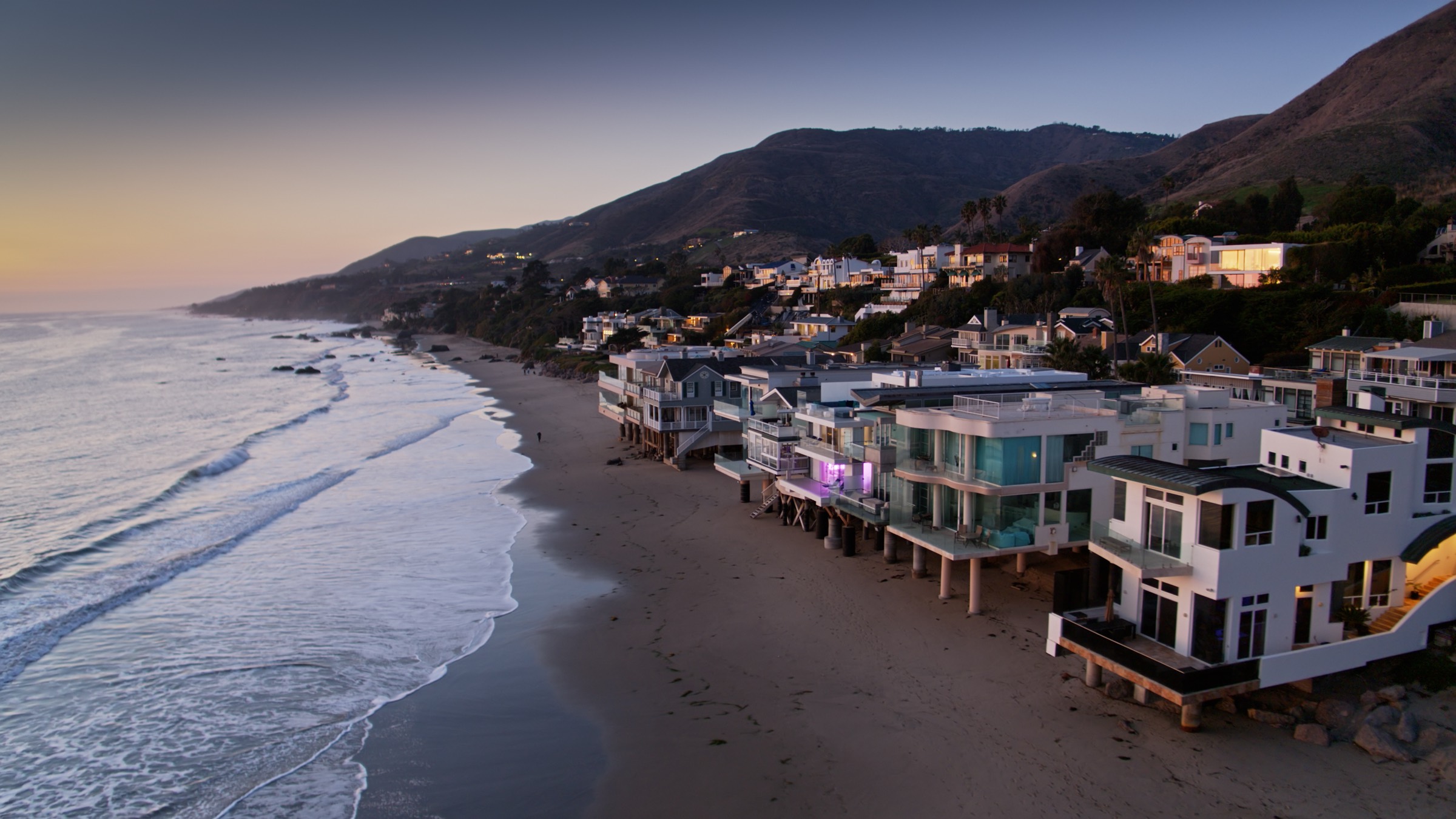 Coastal homes along the Malibu shoreline at sunset